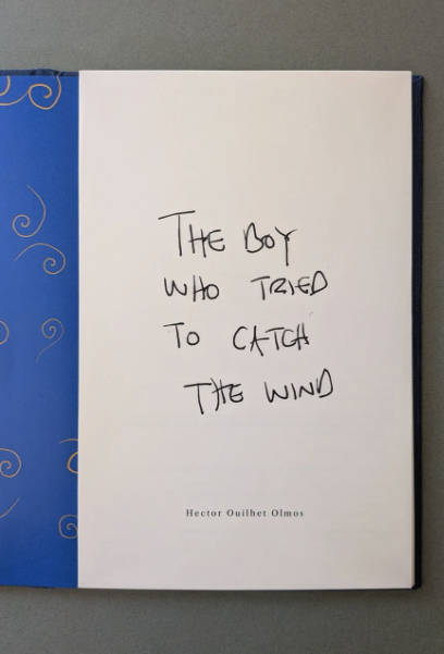 Open book showing a blue endpaper and the handwritten title page